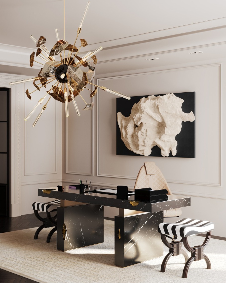 A modern minimalist office with a black marble desk, two striped stools, a sculptural chandelier, and abstract wall art on light-colored walls—perfect for those seeking inspiring office design ideas.