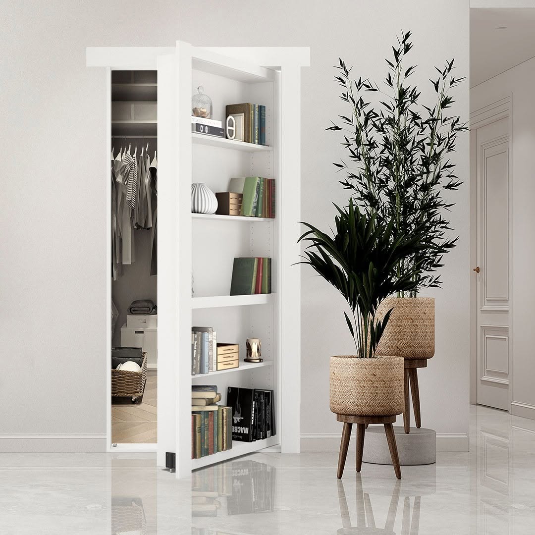 A white sliding bookshelf door, cleverly designed as one of the latest hidden door ideas, stands partially open to reveal a walk-in closet; two potted plants sit nearby on a shiny floor in a modern interior.