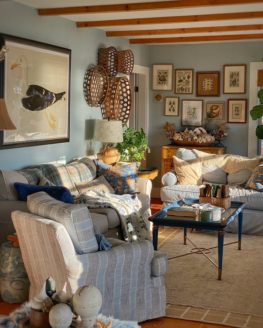 Elegant french country living room with ornate moldings, two sofas, marble fireplace, glass coffee tables, armchairs, and decorative mirrors, featuring a neutral color palette with gold accents.
