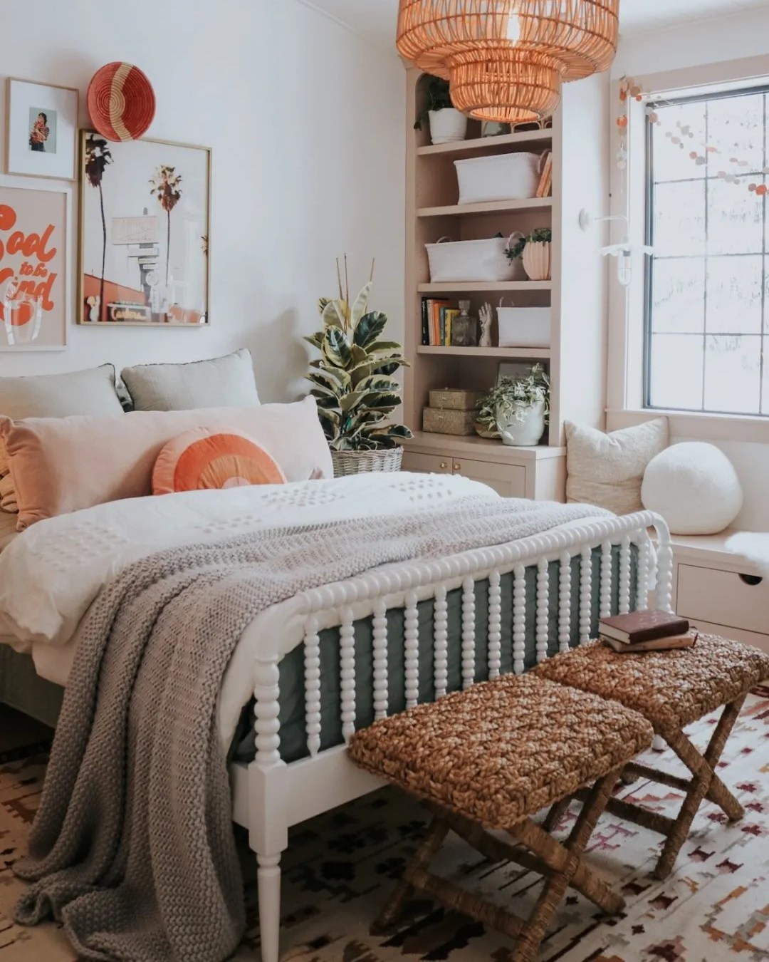 A cozy teen girl bedroom with a white spindle bed, gray and peach bedding, woven benches, a window seat, built-in shelves, and a rattan light fixture.