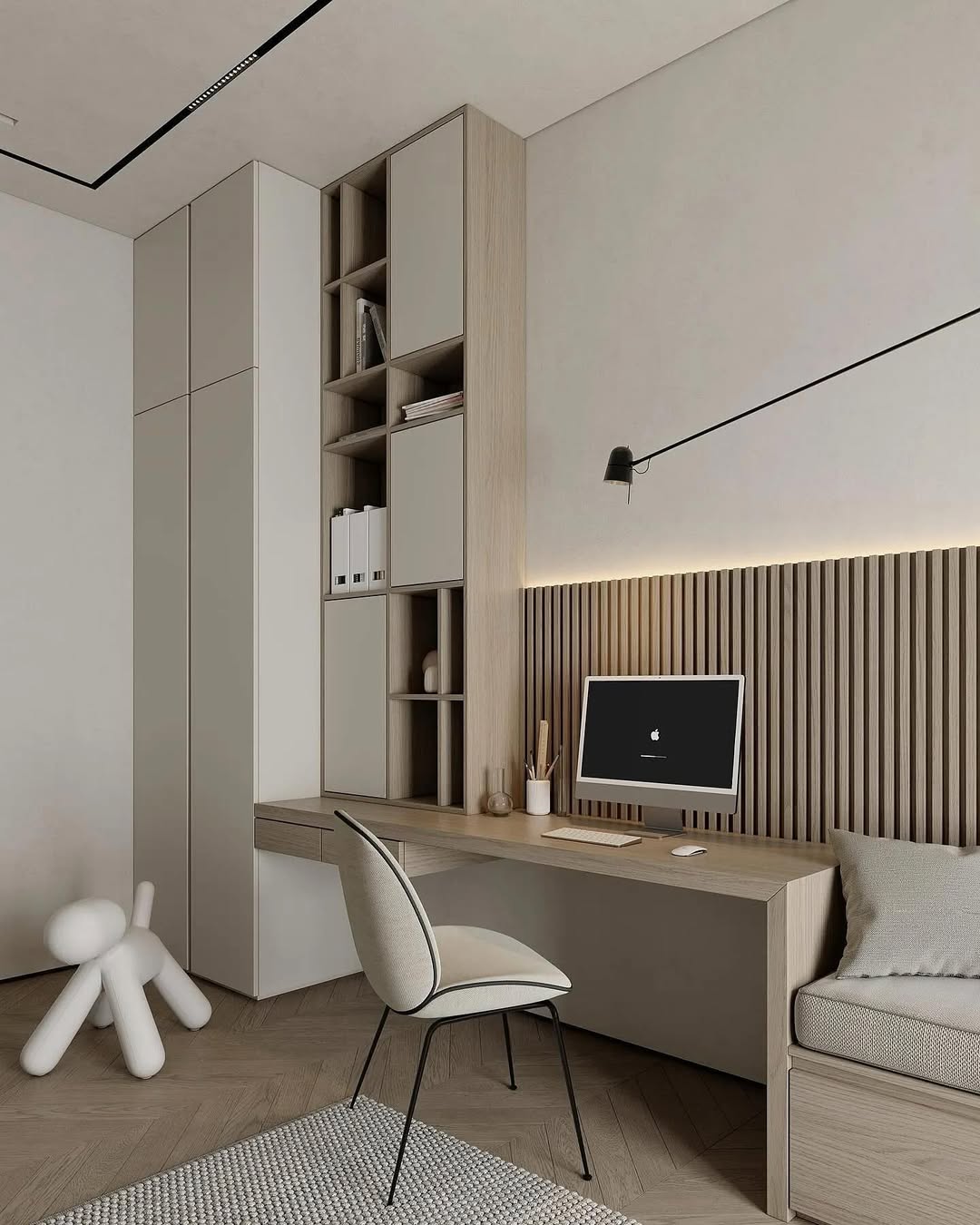 Minimalist office design with built-in desk, shelves, and computer; light wood and neutral tones create a calm workspace. A decorative dog figurine rests on the floor, while a wall-mounted lamp above the desk adds inspiration for modern office design ideas.