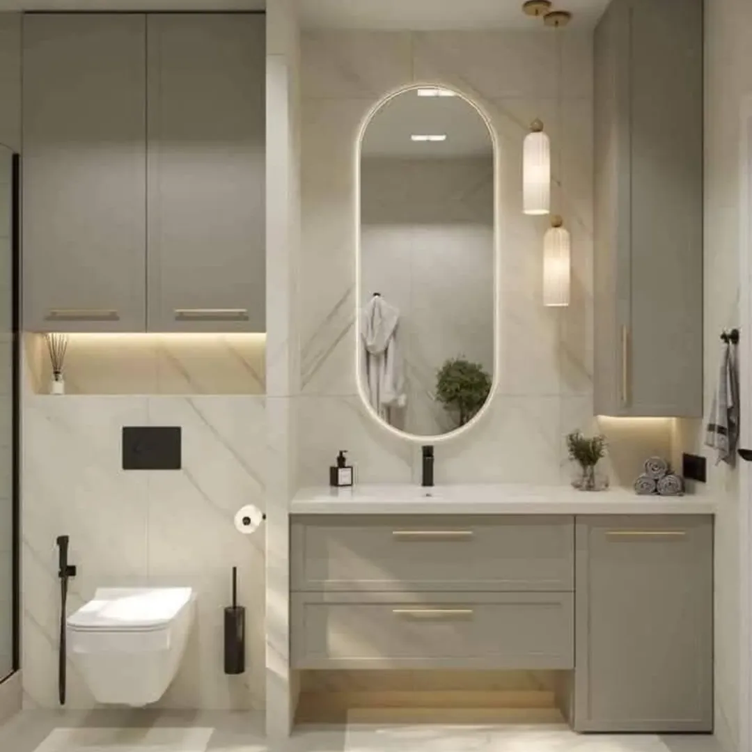 Modern bathroom with floating toilet, large oval mirror, under-cabinet lighting, and pendant lights. Perfect for Half Bathroom Ideas or Powder Room Design with gray cabinets and neutral marble walls and floors.
