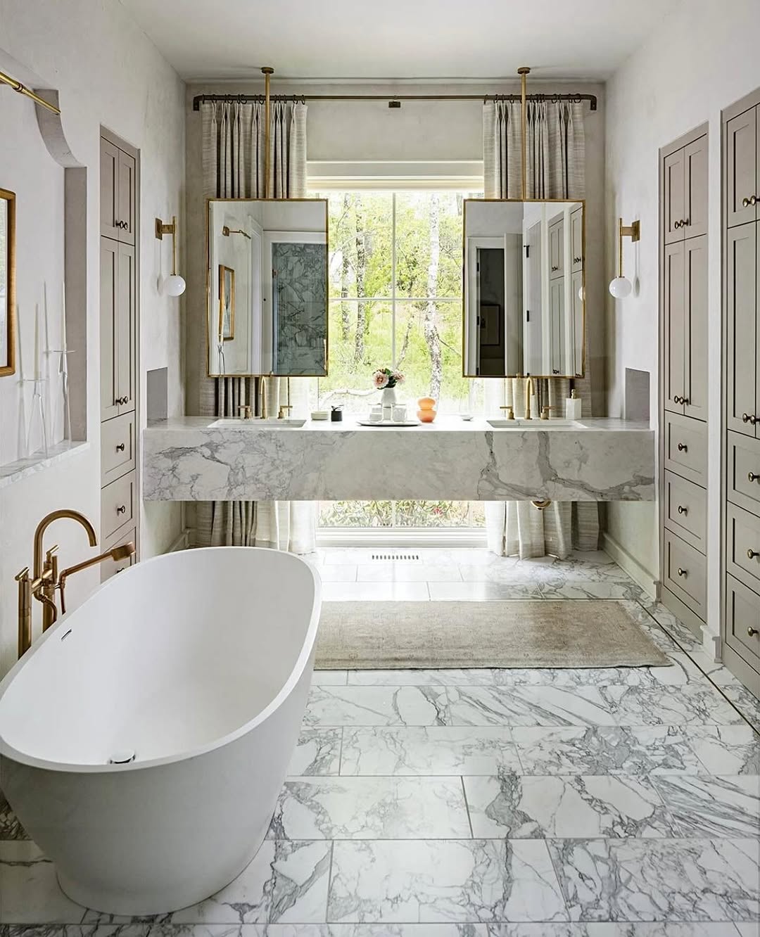 Modern marble bathroom with a glass-enclosed shower, black fixtures, white double sink vanity, and marble-patterned floor tiles—perfect for those seeking fresh marble bathroom ideas.