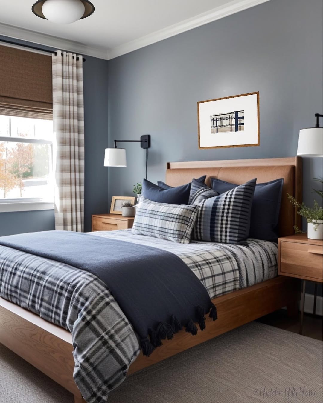 A neatly made bed with plaid bedding in a modern teen boy bedroom featuring blue walls, wooden furniture, wall lamps, a window with plaid curtains, and framed art above the headboard.