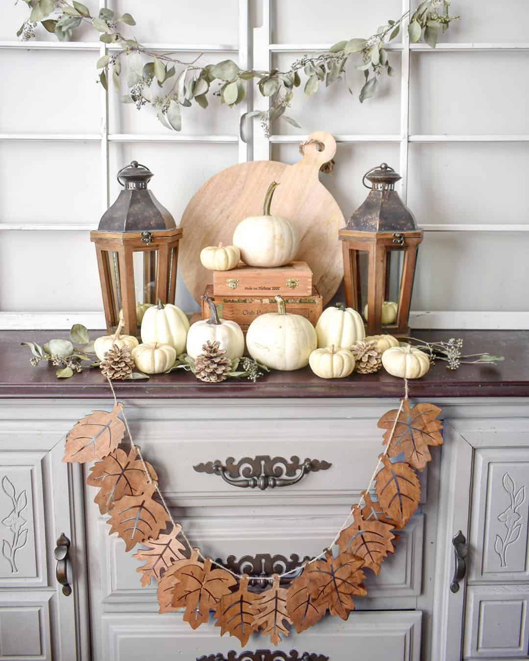 Wooden Lanterns Frame a Stacked Pumpkin Display