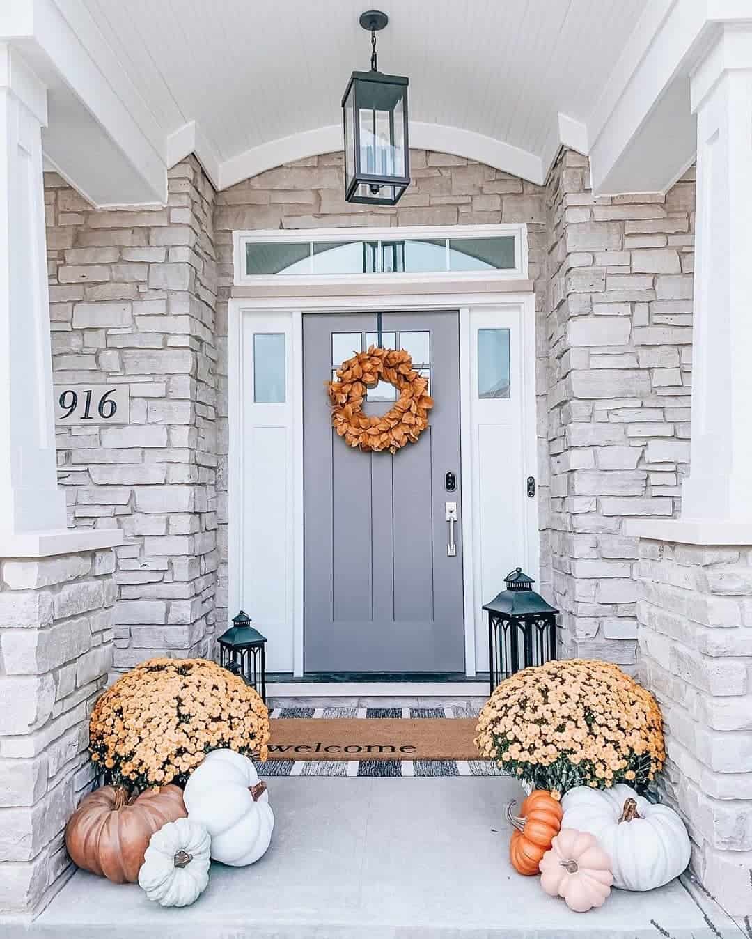Tall Black Lanterns Flank Mums and Pumpkins