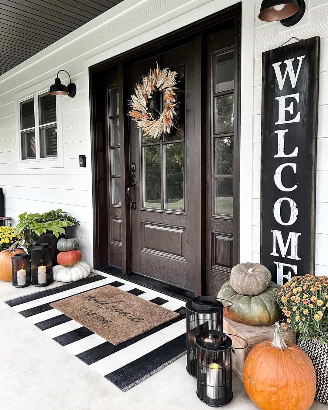 Tall Black Lanterns Frame a Stacked Pumpkin Display