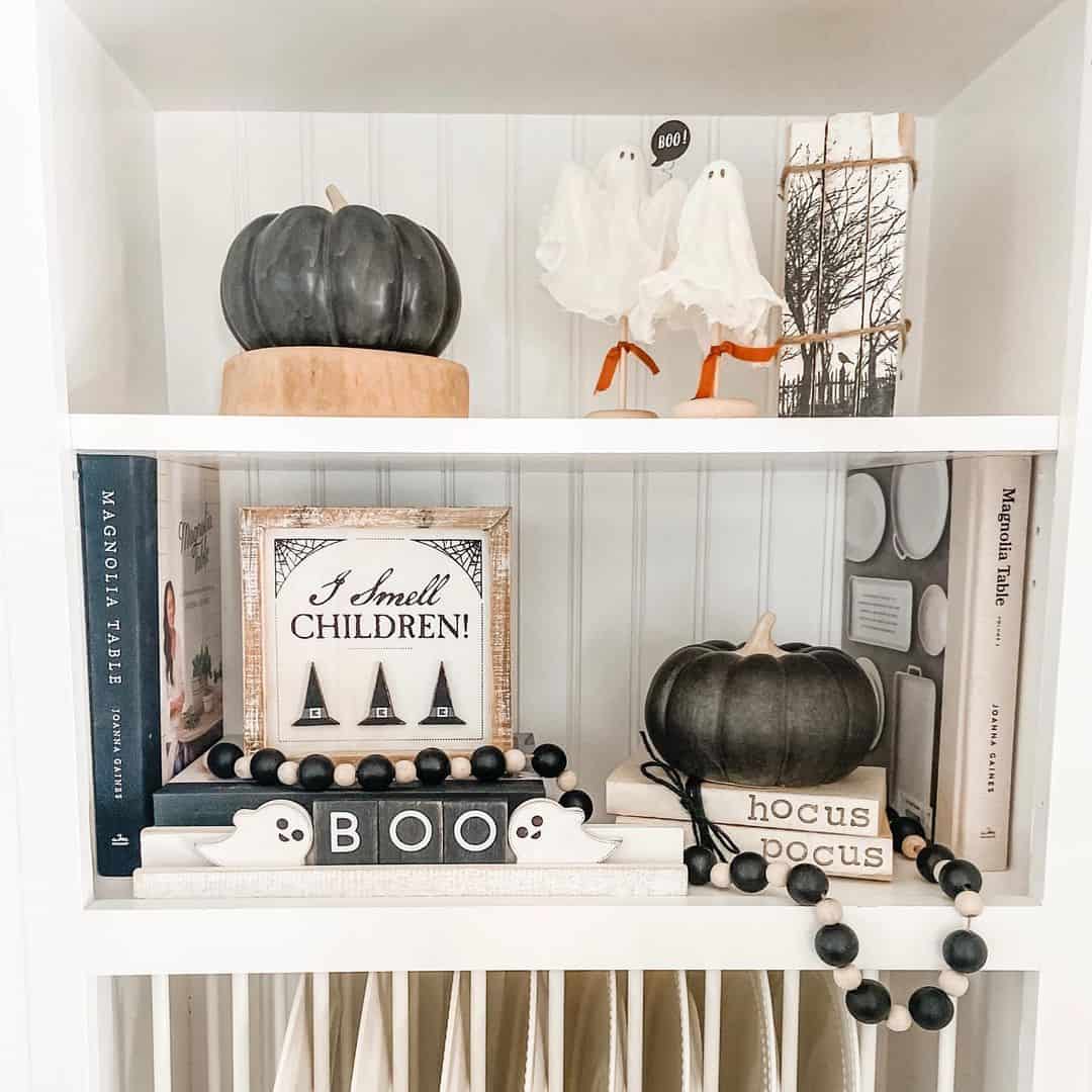 Black Pumpkins Anchor a Halloween Vignette on Books