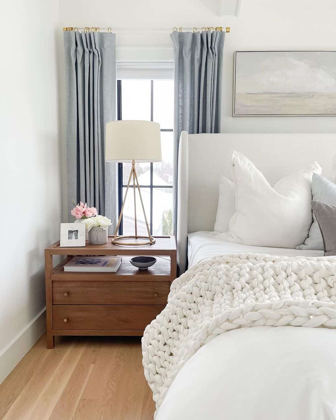 Large Gold Lamp and Pink Flowers on a Wooden Nightstand