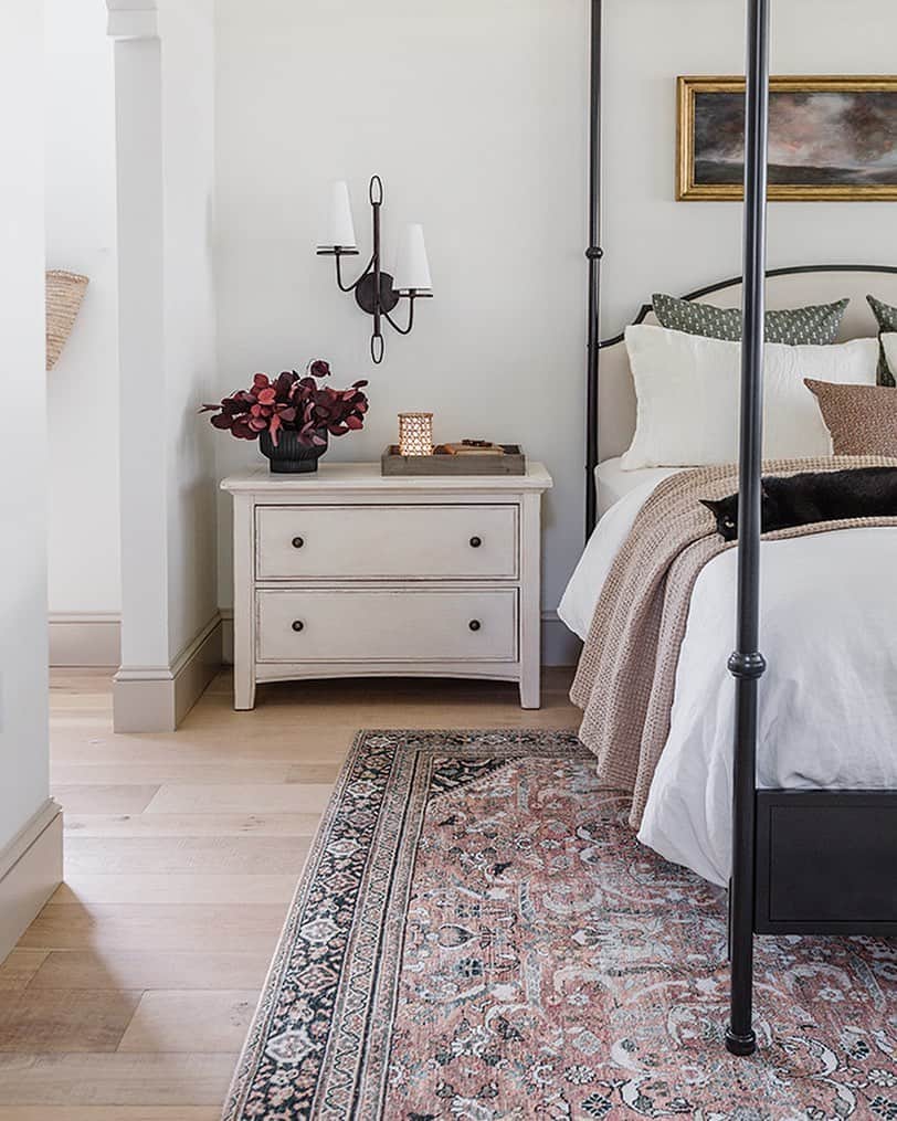 Black Sconce Over a Wide White Nightstand