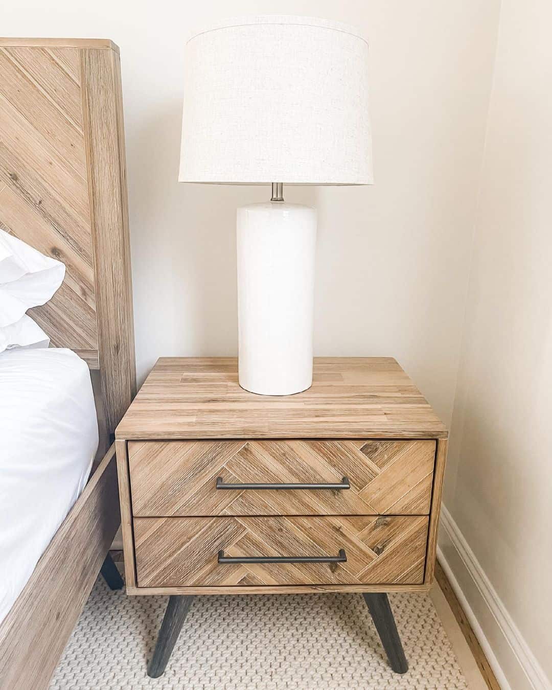 White Lamp on a Natural Wood Herringbone Nightstand