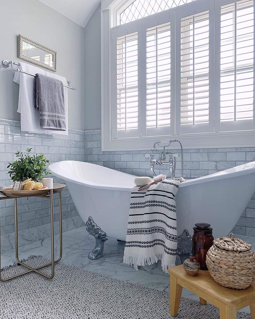 Clawfoot Bathtub Beneath White Shutter Windows